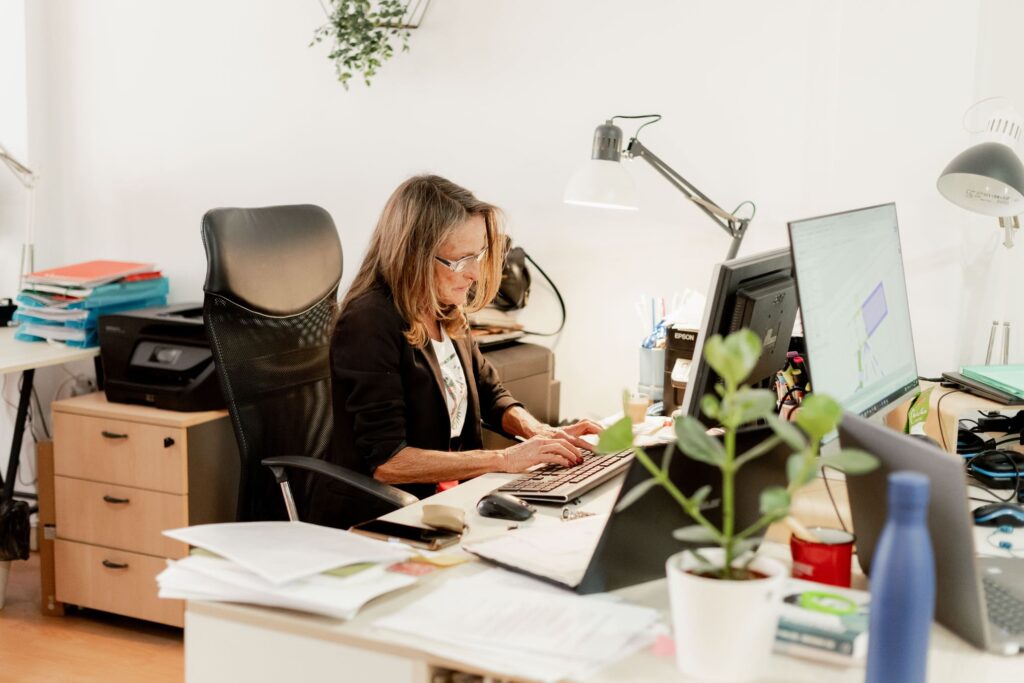 Mujer trabajando en el ordenador en un puesto alquilado de un coworking 